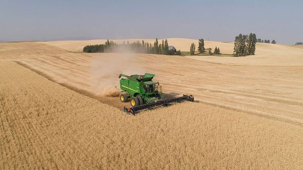 Aerial view of a John Deere combine cutting wheat on a sunny afternoon-Spokane County